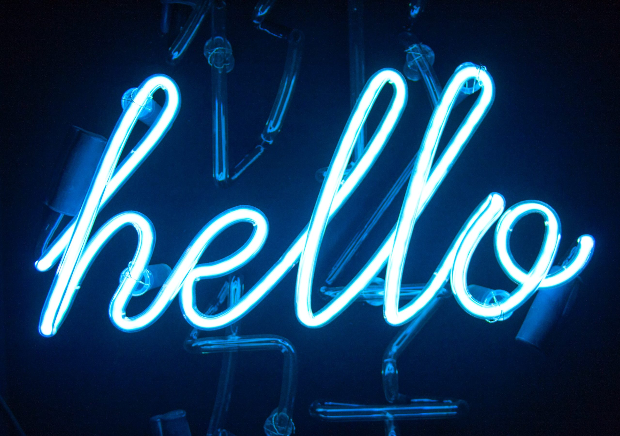 Blue neon sign in cursive writings that says hello